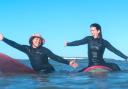 Two women having fun surfing at Compton during the inaugural Wight Wahines Surfing Festival.