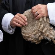 A barrister holding a wig