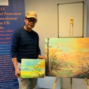 Amangpintor next to one of his recent works, worth approximately £500)