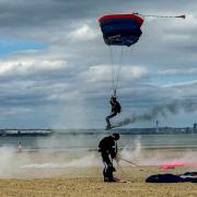 Royal Navy parachute team land on beach.