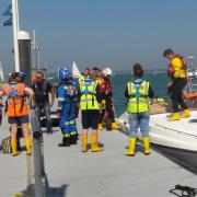 The motor cruiser pictured alongside Trinity Landing and after being towed to safety by Cowes lifeboat