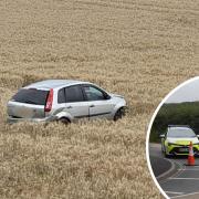 Car in a field and inset, road closure.