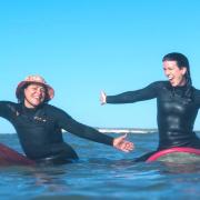 Two women having fun surfing at Compton during the inaugural Wight Wahines Surfing Festival.