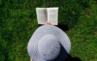 A woman in a hat reading. Credit: Canva