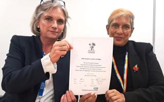 The signed Armed Forces Covenant, being held by Maggie MacIsaac, chief executive of the Hampshire and Isle of Wight NHS Trust, left, and Lena Samuels, the trust's chair.