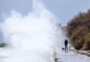 A dog walker comes face to face with a huge wave on Totland Bay promenade