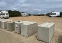 Concrete bollards block a community of travellers in.