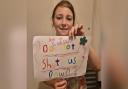 Godshill Primary School student, Lacey Dupré, nine, holding a banner she made.