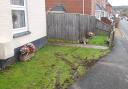 A car crashed through a fence and came to rest inches from a pensioner's home.