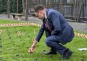 Richard Quigley placing a cross on behalf of IW West in the Constituency Garden of Remembrance