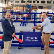 MP Bob Seely, right, cuts the ribbon on the production line at Britten-Norman in Bembridge while chief executive, William Hynett, watches on.