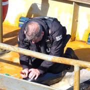 A specialist police officer checking every inch of a boat seized in Yarmouth.