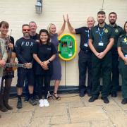 The team from The Three Bishops at Brighstone celebrate the arrival of their new life saving public access defibrillator alongside colleagues from the Isle of Wight Ambulance Service.