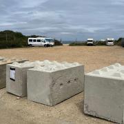 Concrete bollards block a community of travellers in.