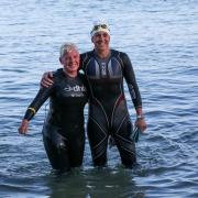 Crys and swim buddy Holly Bartley arrive at Colwell Bay and celebrate finishing the swim