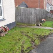 A car crashed through a fence and came to rest inches from a pensioner's home.