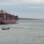 Container ship One Maneuver being assisted by three tug boats and the harbour master.