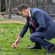 Richard Quigley placing a cross on behalf of IW West in the Constituency Garden of Remembrance