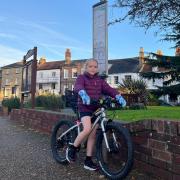 Maggie on her bike at the bus stop