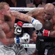 Jake Paul, left, fights Mike Tyson during their heavyweight boxing match in Arlington, Texas (Julio Cortez/AP)