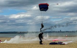 Royal Navy parachute team land on beach.